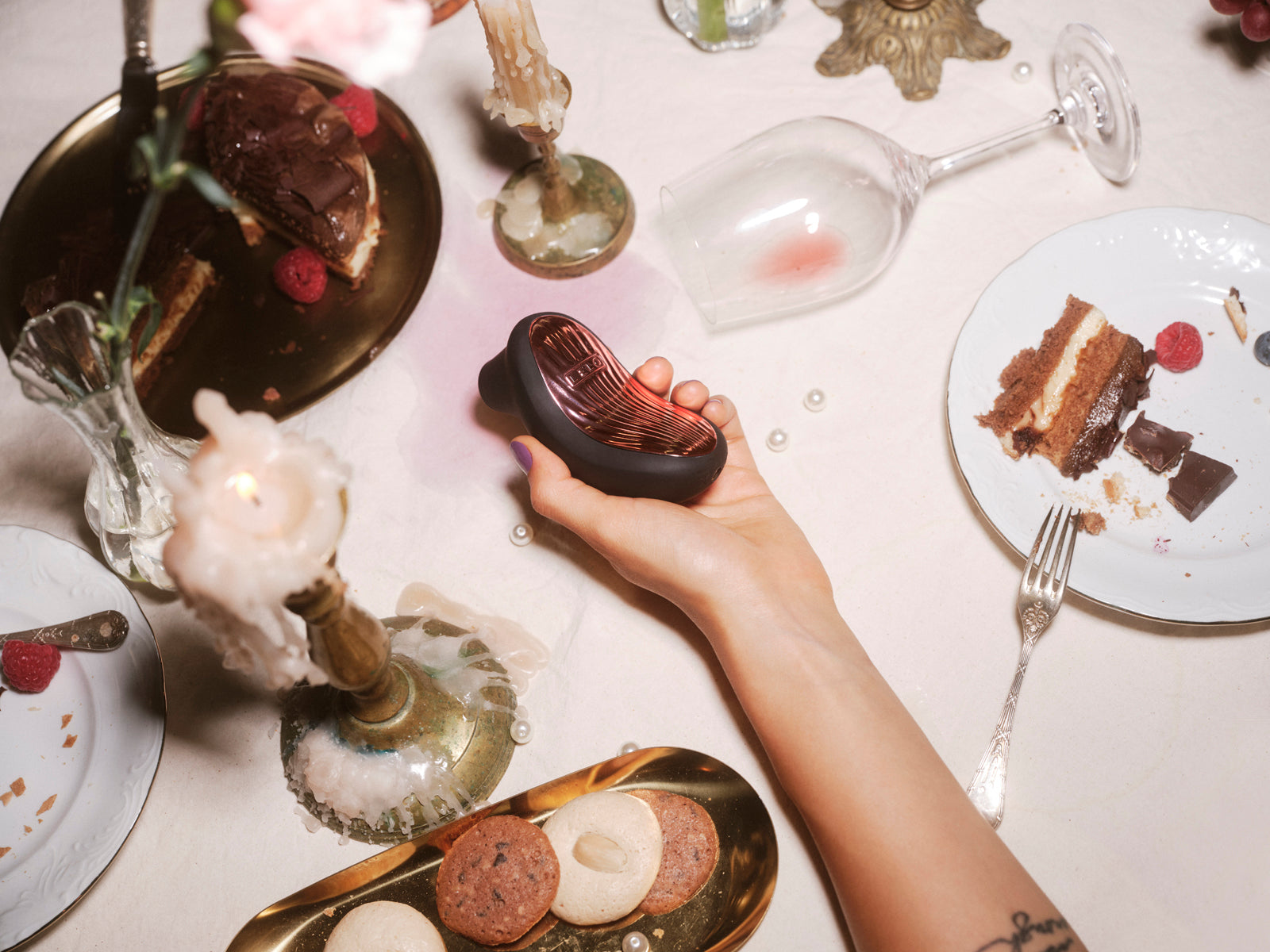 LELO SONA 3 Cruise held above an intimate candlelit dinner table